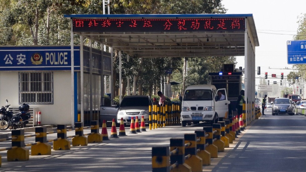 Uigurer får sina fordon kontrollerade vid en poliskontrollplats i Hotan i Xinjiang. Arkivbild.