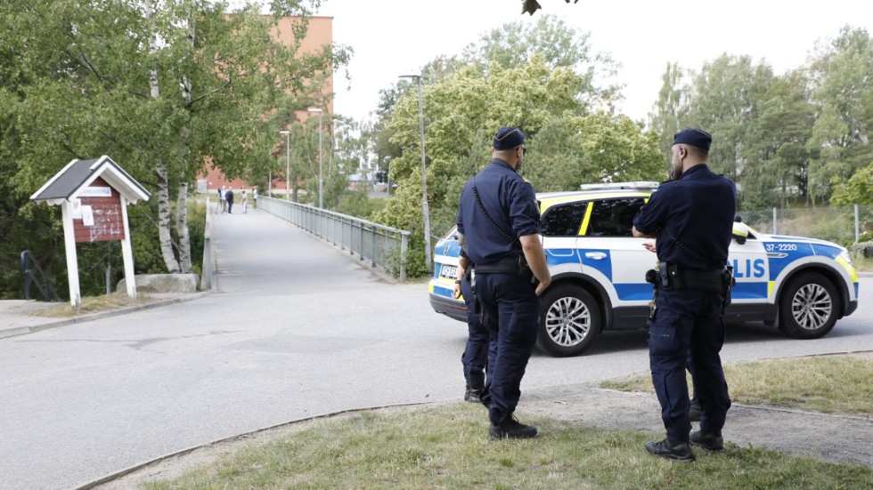 Poliser på plats vid gångbron i Visättra, Flemingsberg, där två barn skottskadades i en skjutning som tros vara riktad mot någon annan. Arkivbild från den 18 juli.