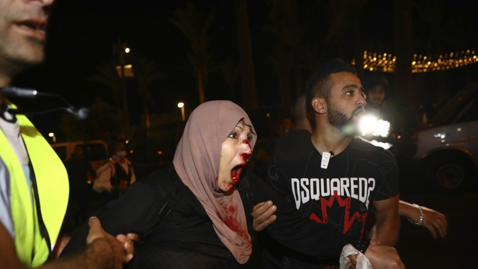 En skadad palestinsk demonstrant tas om hand i området Sheik Jarrah i östra Jerusalem.