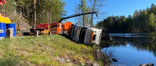 BILDERNA: Här bärgas timmerbilen efter olyckan · Körde av vägen och ner i sjö