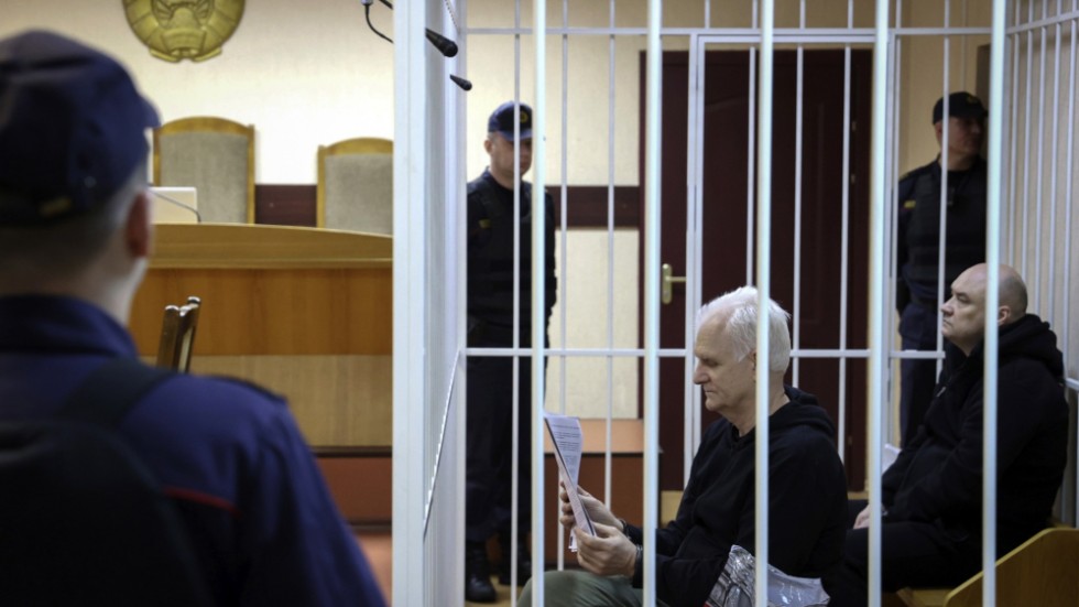 Ales Bjaljatski sitter och läser i domstolen i Minsk, den 5 januari. Till höger om honom i bild sitter den medåtalade kollegan Valjantsin Stefanovic. Arkivbild.