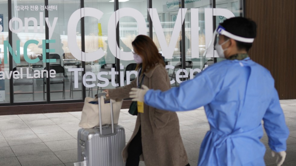 En kvinna som anländer till Sydkorea från Kina blir visad till en plats där hon kan covidtestas på flygplatsen. Arkivbild.