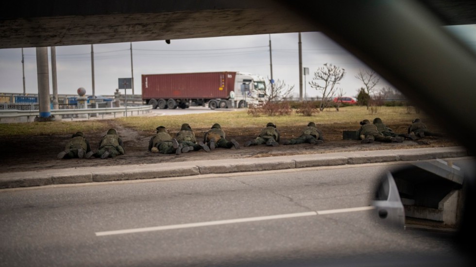 Ukrainska soldater positionerar sig under en bro under sammandrabbningar med ryska styrkor i huvudstaden Kiev på fredagen.