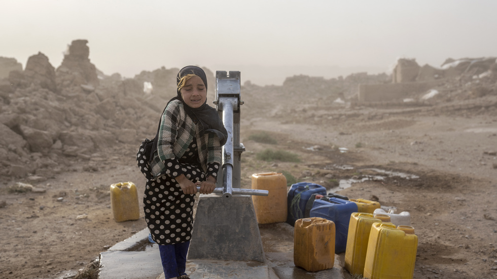En afghansk flicka fyller vattendunkar från en brunn i Zenda Jan i västra Afghanistan. Hon står i en sandstorm, några dagar efter det katastrofala jordskalvet i början av oktober där fler än 2|000 personer omkom. Arkivbild.