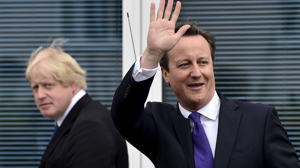 Storbritanniens dåvarande premiärminister David Cameron - med sedermera efterträdaren Boris Johnson i bakgrunden - efter ett valmöte 2015. Arkivbild.