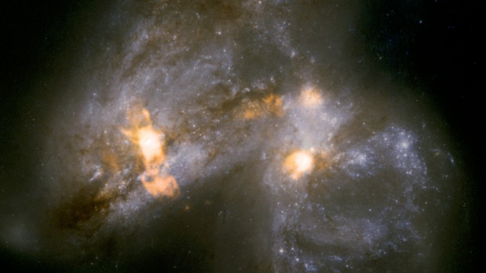 Galaxparet Arp 299 håller på att smälta samman. Lofar avslöjar hur vindar lika stora som en galax blåser ut från en jättelik stjärnfabrik som ligger dold bakom lager av stoft och damm i galaxernas ena kärna.