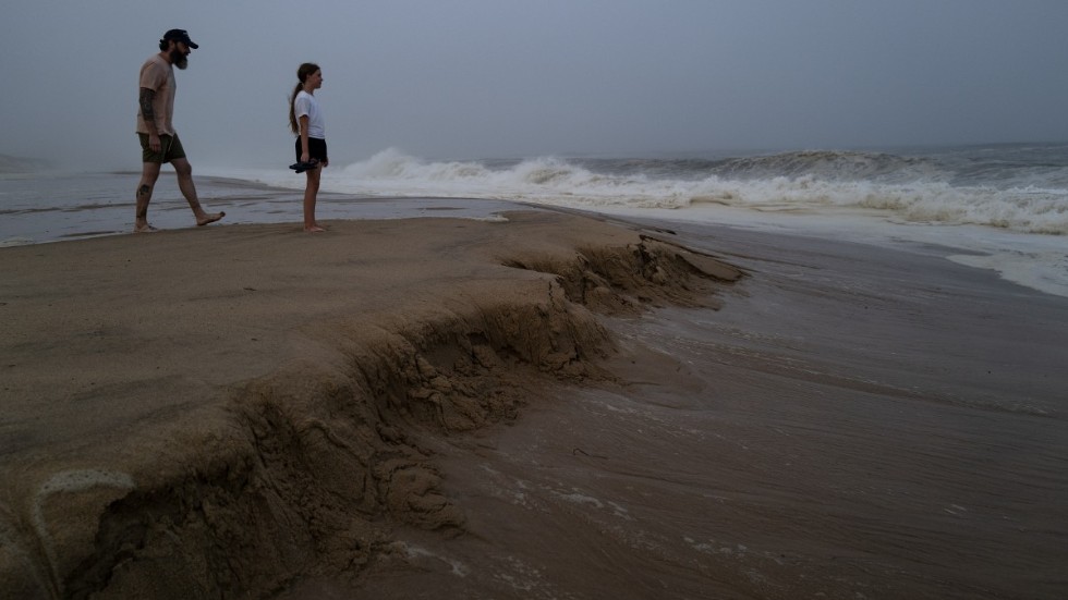 Ryan Madigan och hans elvaåriga dotter Charolette spanar på vågorna som piskas upp när orkanen Henri närmar sig. Bilden är tagen på stranden i Montauk på Long Island i New York.