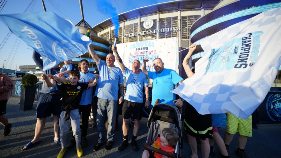 Fans till Manchester City firar klubbens tredje raka ligatitel utanför hemmaarenan.