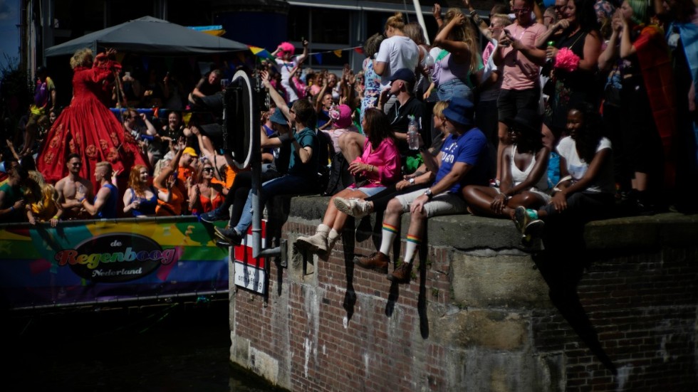 Hundratusental människor beräknas ha samlats på broar och längs kanaler för att följa Amsterdams färgsprakande flytande prideparad.