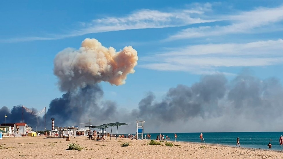 En rökpelare stiger bortom en strand på den annekterade Krimhalvön den 9 augusti. Smällar som dånade i området tros ha orsakats av ukrainsk beskjutning mot en rysk flygbas. Arkivbild.