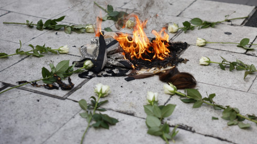 En slöja bränns under en demonstration på Sergels torg till stöd för de folkliga protesterna som började i Iran i samband med en 23-årig kvinnas död.