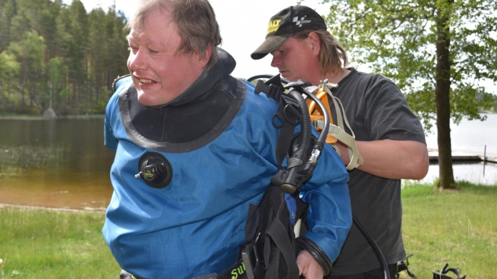 Rolf Åberg går dykarutbildning och får hjälp med utrustningen av Neo Andersson som är instruktör.