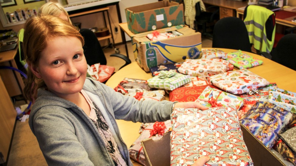 Elin Sandberg lägger ner julklappar i pappkartonger. De närmaste dagarna kommer paketen att köras från Heby skola till Västerås och sedan till barn i Rumänien, Ukraina och Moldavien.