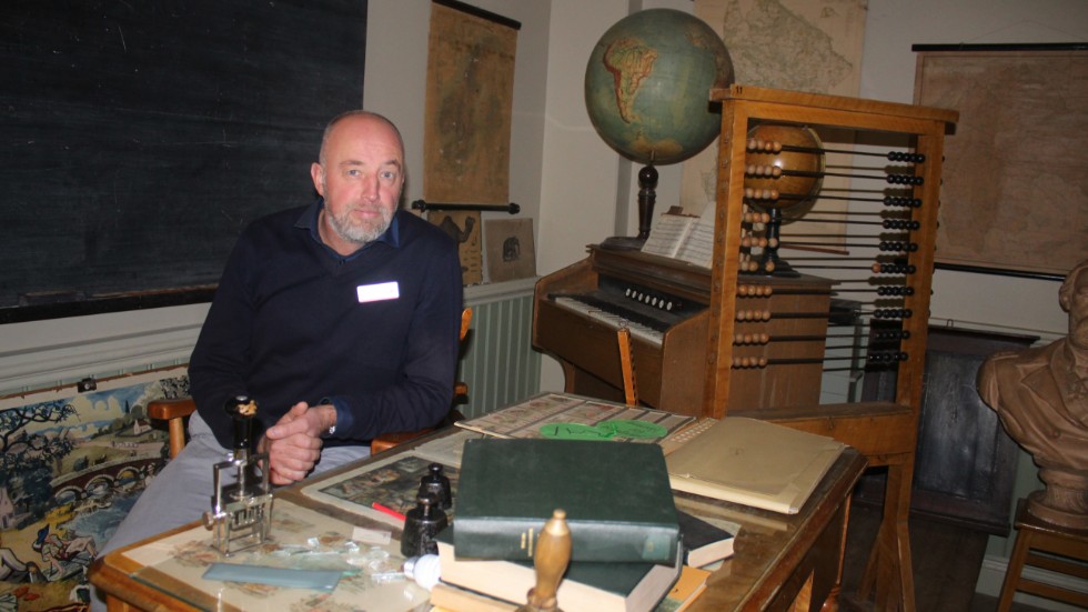 Rektorn Magnus Stark visade upp skolmuseets samlingar för Folkbladet och provsitter själv en gammal kateder.