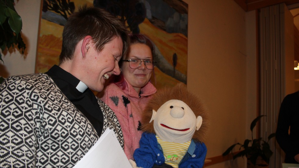 Dockan Sigge sprider glädje omkring sig. Kyrkoherde Kirsten Alm och församlingspedagog Elin Holmberg kan inte låta bli att skratta i Sigges närhet. 