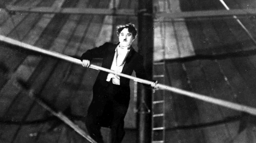 Charlie Chaplin (1889–1977) är en av flera komiker som porträtteras i boken "Komikernas historia". Här en bild på Charlie Chaplin från stumfilmen "Cirkus" (1928)