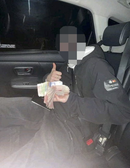 Den nu dömde 16-åringen poserar med pengar han ska ha fått för att utföra mordet. Bild från polisens förundersökning.