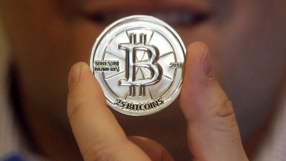 Den digitala valutan bitcoin (representerad av en symbolisk peng på bild), föll brant i helgen men har stabiliserats strax under 50|000 dollar på måndag förmiddag. Arkivbild.