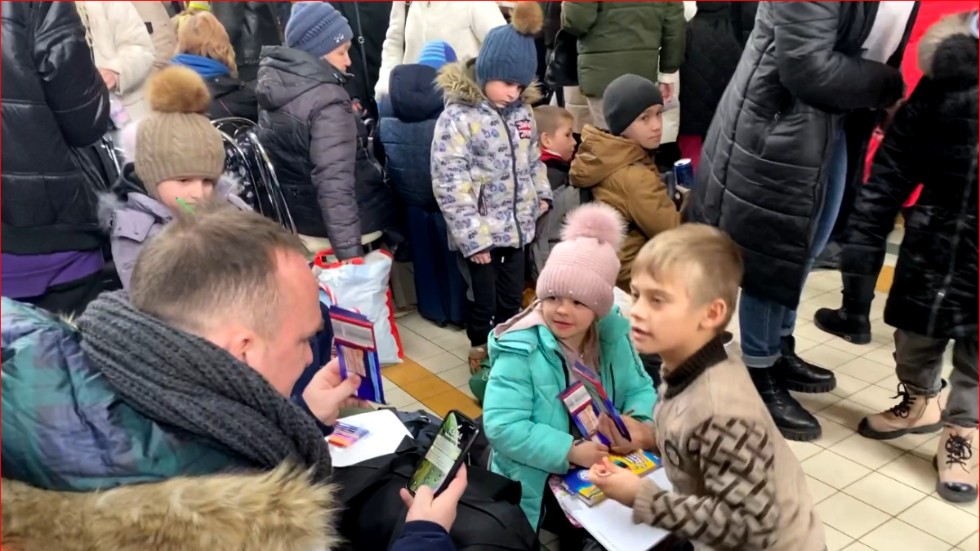Barn på flykt uppmuntras av en volontär på järnvägsstationen i Przemysl onsdagen den 9 mars 2022.