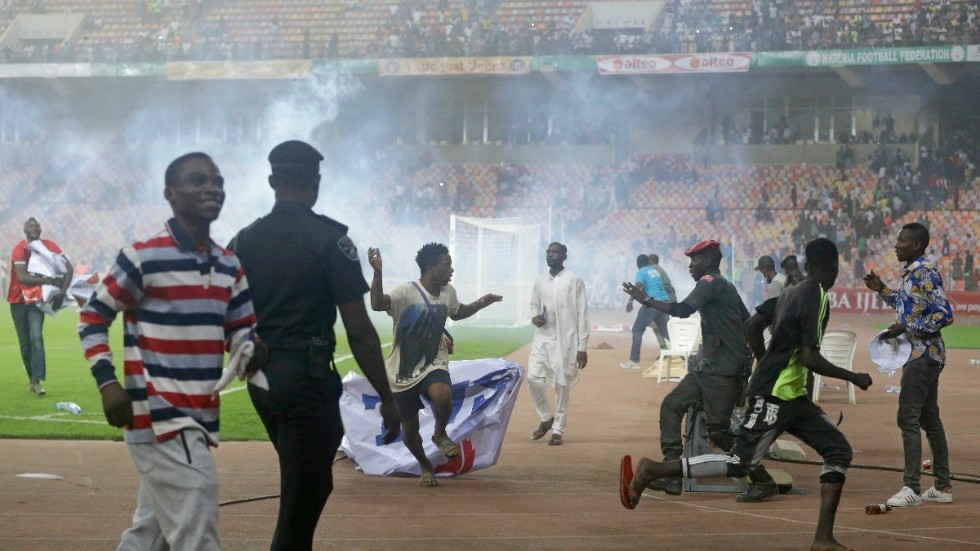 Polis försöker stoppa planstormningen efter matchen mellan Nigeria och Ghana.