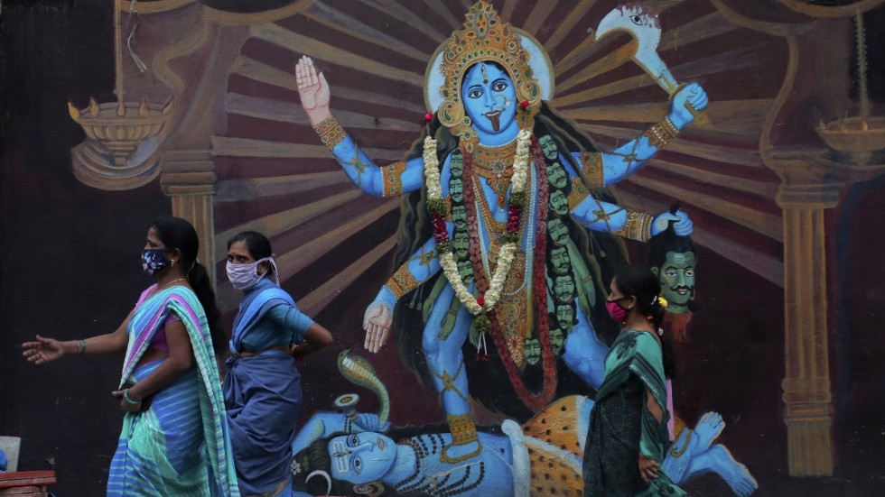 Indiska kvinnor passerar ett altare till gudinnan Durga i Hyderabad. Antalet coronasmittade i Indien har passerat sju miljoner, när hinduernas festivalsäsong just ska börja.