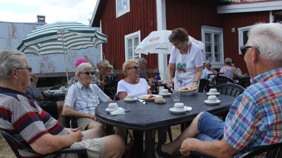 Ulla-Maj Svensson serverar våfflor till fyra av gästerna, Lennart Landström, Eivor Landström, Viola Nilsson och Ulf Nilsson.