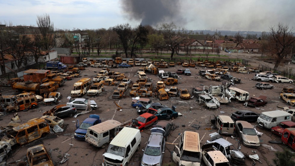 Skadade och utbrunna fordon i Mariupol, där rök ses stiga från stålverket Azovstal på måndagen.