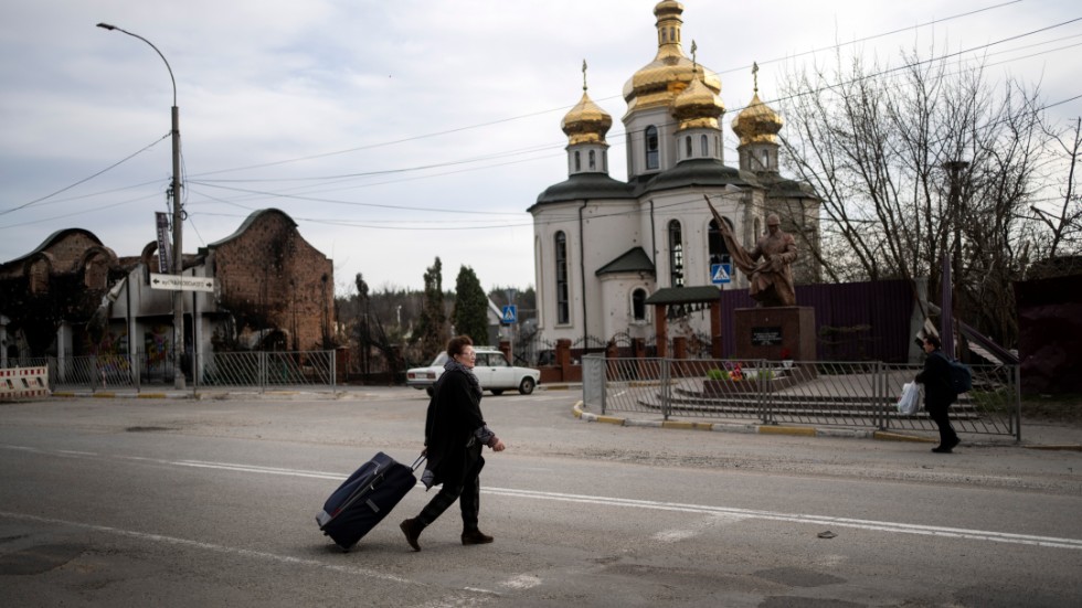 74-åriga Yanina går med sitt bagage mot sitt hus i Irpin, utanför Kiev, i mitten av april. Hon lämnade hemmet i mars, men känner sig nu tillräckligt trygg för att återvända.