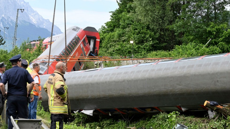 Räddningspersonal vid olycksplatsen nära Garmisch-Partenkirchen i södra Tyskland, där ett persontåg spårade ut i fredags. Minst fem människor omkom.