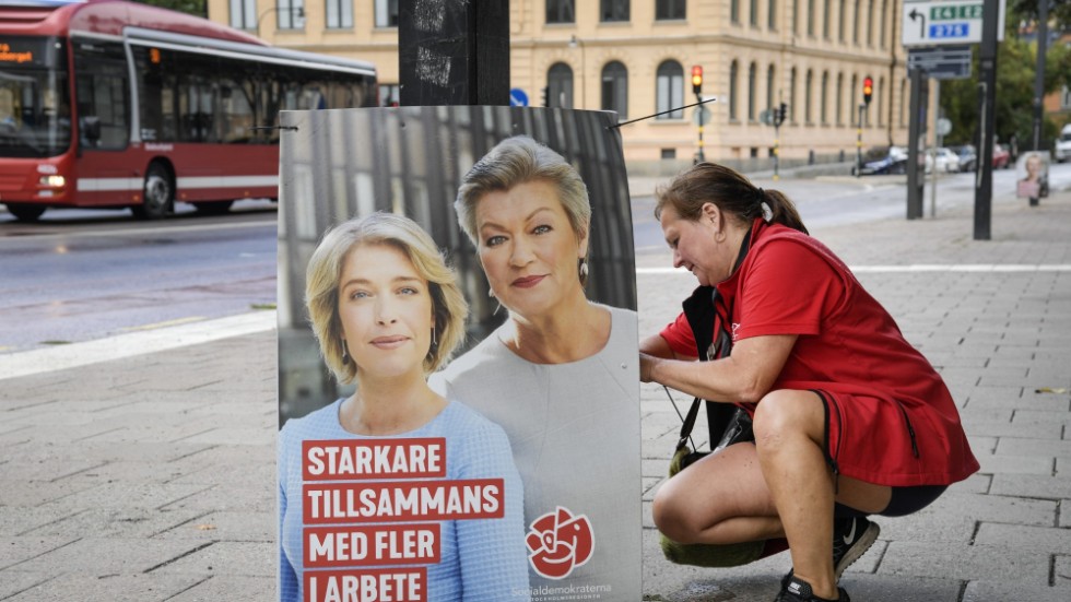 En socialdemokratisk valarbetare vid en affisch som lovade fler jobb vid valet 2018.