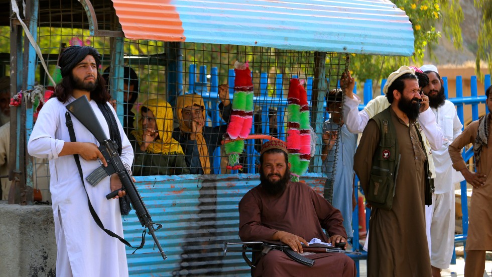 Stridande talibaner patrullerar på den afghanska sidan av en gränsövergång till Pakistan. Extremiströrelsen kontrollerar nu Afghanistan.