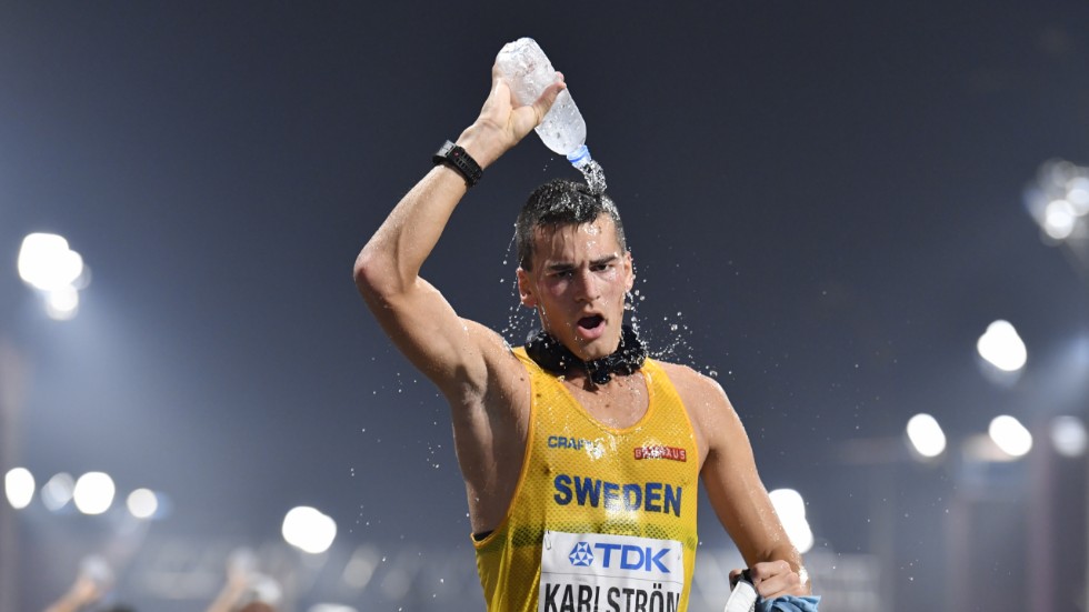 Perseus Karlström – med "iskorven" runt halsen – svalkar sig med vatten under gångtävlingen i friidrotts-VM i Doha 2019. Arkivbild.