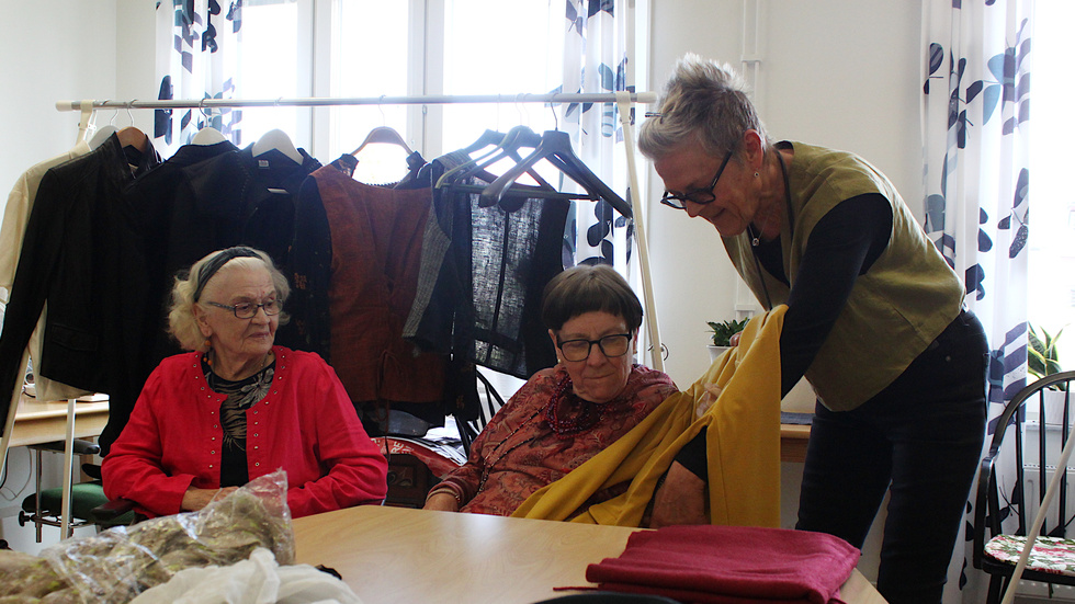 Maija Pulkkinen-Sandman, 90 och Gunilla Karlsson, 72, får känna på materialet. "Vi kan lova att varje plagg håller kvalitet och att de blir ensamma om det", säger Monica Kårbro.