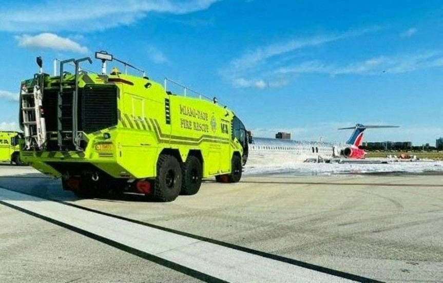 Räddningstjänst på väg mot flygplanet som fattade eld vid landning på Miamis internationella flygplats sent på tisdagskvällen.