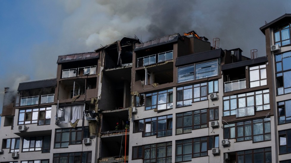 Rök stiger från ett bostadshus efter söndagsmorgonens explosioner i Kiev.