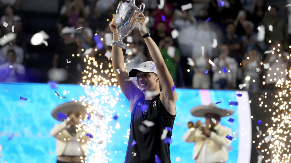 Iga Swiatek, från Polen, håller upp segerpokalen efter vinsten mot Jessica Pegula i WTA-slutspelets final.
