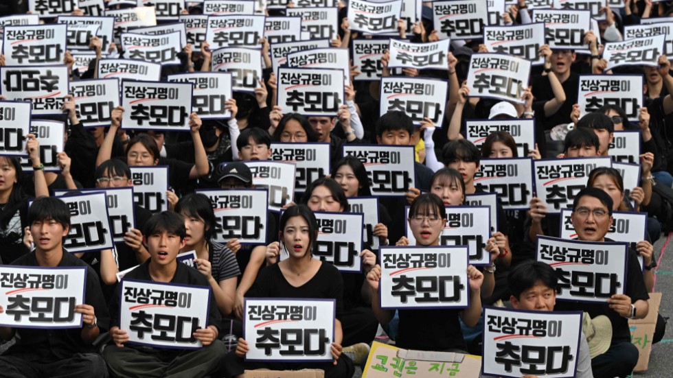 Demonstranter i Seoul. På plakaten står det "Att avslöja sanningen är ett sätt att visa respekt".