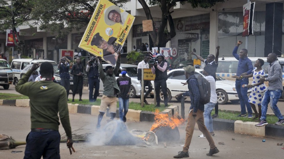 En anhängare till oppositionskandidaten Bobi Winer gör sig redo att elda upp en bild föreställande den sittande presidenten Yoweri Museveni i Kampala. Arkivbild.