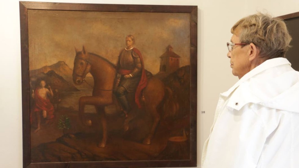 Gunvor Djurberg från föreningen Kopparslagaren tittar på ett självporträtt av Robin Holmqvist, en av konstnärerna som ställer ut på galleriet.