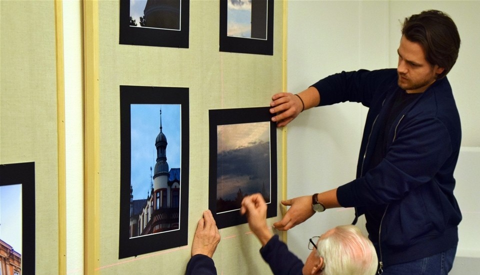 Einar Samuelsson och Erik Widén, Kisa Fotoklubb hjälper de andra medlemmarna att sätta upp även deras bilder. Foto: Morgan Karlsson