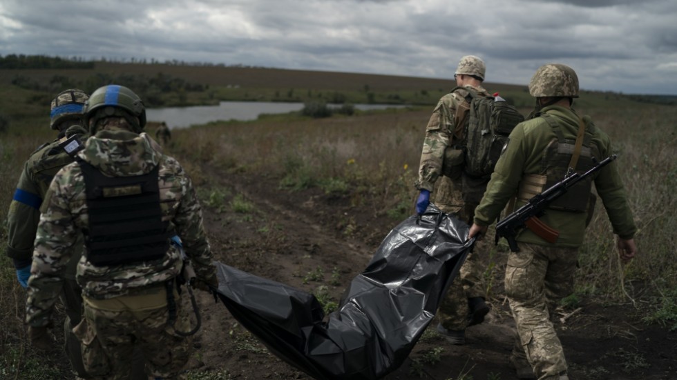 En död ukrainsk soldat bärs bort av sina kollegor i Charkiv-regionen nära den ryska gränsen. Arkivbild.