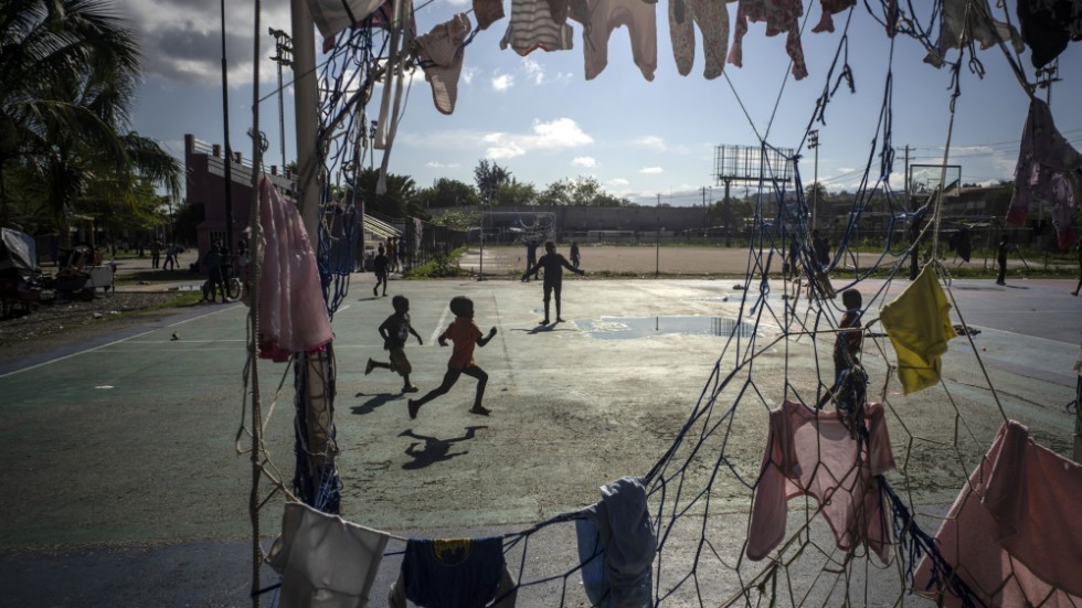 Barn springer på en fotbollsplan i Port-au-Prince där målet används som tvättställning. Bild från oktober 2022.