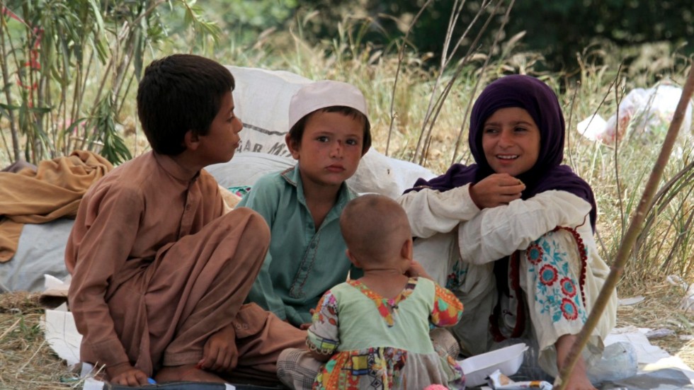 Barn som tvingats lämna sina hem vilar under ett provisoriskt tält längs vägen i Charsadda, strax norr om Peshawar i Pakistan.