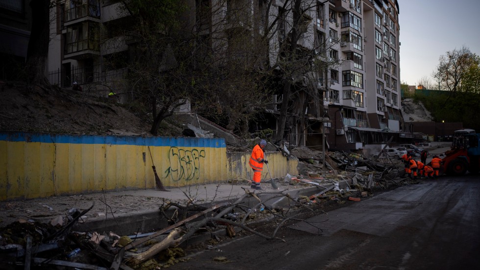 Städpersonal rensar upp efter ett flyganfall i Kiev.