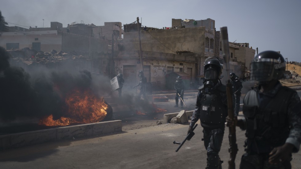 Polis avlägsnar brinnande däck i huvudstaden Dakar på fredagen efter en protest i området.