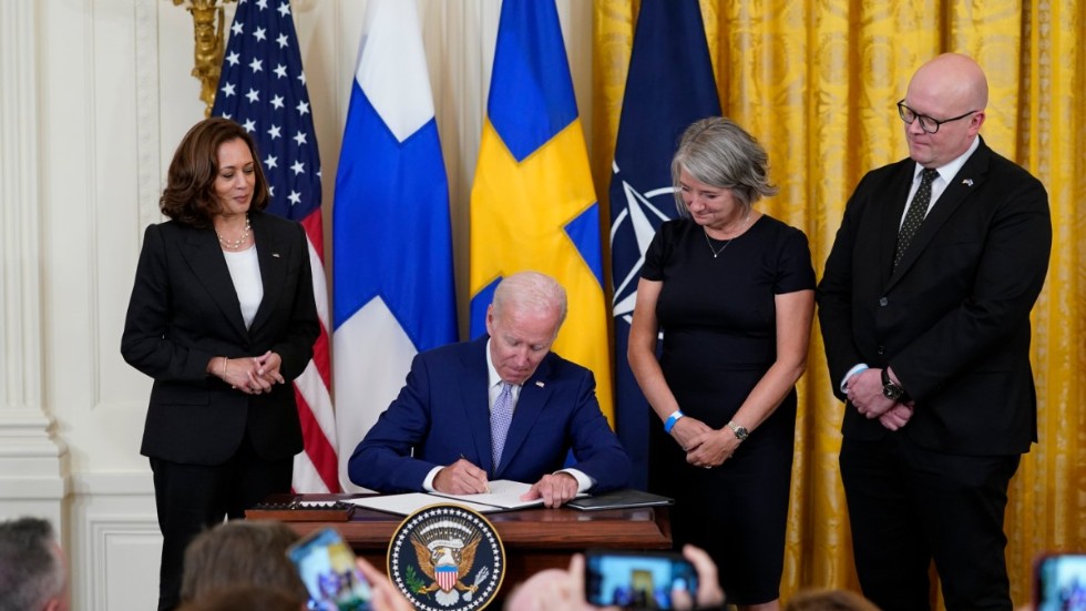 USA:s President Joe Biden undertecknar Sverige och Finlands Natoansökningar under överinseende av vicepresidenten Kamala Harris (t.v.) och Sverigs ambassadör Karin Olofsdotter samt Finlands ambassadör Mikko Hautala (t.h.)
