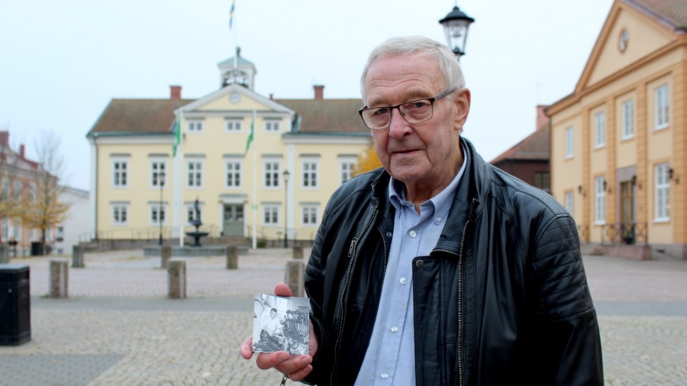 Olle Larsson håller i en bild från när han jobbade som grafiker på Vimmerby Tidning. Tryckpressen som syns på bilden är samma sort som han nu tryckt sin bok i. 