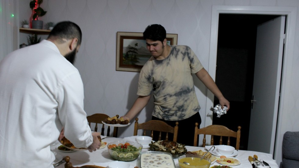 Ryad och Mohamad Walid Arabi Katbi dukar fram maten på bordet. 