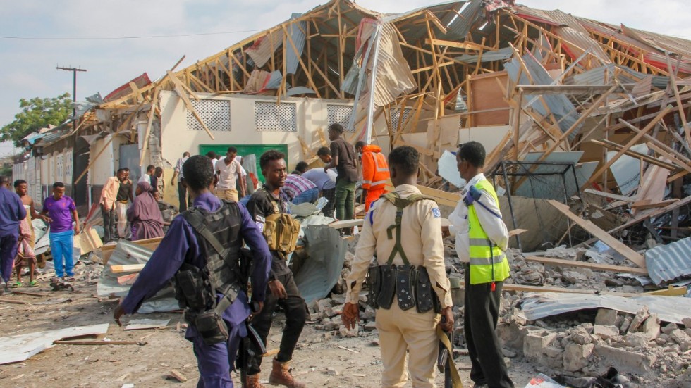 Säkerhetsstyrkor och räddningsarbetare letar efter offer på attentatsplatsen i Mogadishu.