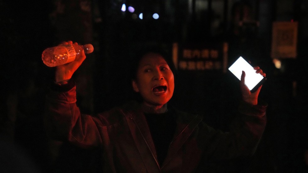 En kvinna protesterar i Peking mot regimens strikta "nollcovid"-politik.